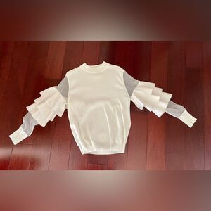 Gently worn cream sweater with sheer and ruffle sleeves